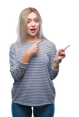 Young blonde woman over isolated background smiling and looking at the camera pointing with two hands and fingers to the side.