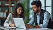 © LuisAlfonso - Indian financial advisors, both male and female, discuss a stock market strategy in a modern company using a laptop computer. Managers from South Asia Work Together on a Banking Project