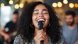 © Lens Legacy - A young woman with curly hair sings passionately into a microphone while on stage, capturing the essence of performance, emotion, and the joy of musical expression.