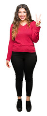 Wall Mural - Young beautiful woman wearing red sweater showing and pointing up with fingers number two while smiling confident and happy.