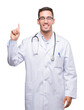 © Krakenimages.com - Handsome young doctor man showing and pointing up with finger number one while smiling confident and happy.