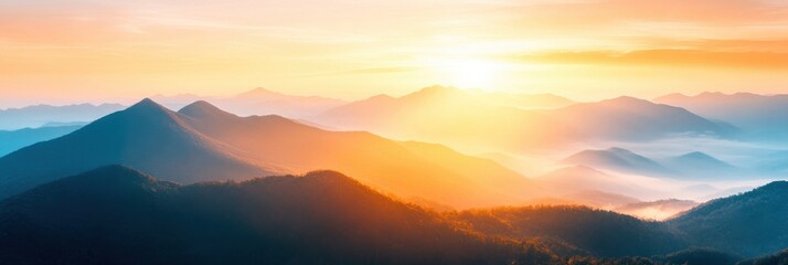 Wall Mural - A breathtaking sunrise casts golden hues over tranquil mountains, enveloping the landscape in soft mist and warmth during the early morning light