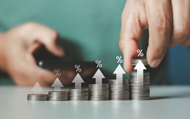 Interest rate and dividend concept. Businessman stacking coins money with up arrow and percentage symbol for financial banking increase interest rate or mortgage investment dividend business growth.