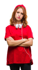 Sticker - Young beautiful hipster woman over isolated background wearing headphones and cap skeptic and nervous, disapproving expression on face with crossed arms. Negative person.