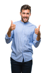 Poster - Young handsome man over isolated background success sign doing positive gesture with hand, thumbs up smiling and happy. Looking at the camera with cheerful expression, winner gesture.