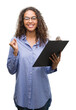 © Krakenimages.com - Young hispanic business woman holding clipboard screaming proud and celebrating victory and success very excited, cheering emotion
