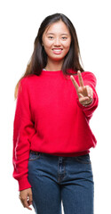 Sticker - Young asian woman wearing winter sweater over isolated background smiling looking to the camera showing fingers doing victory sign. Number two.