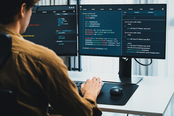 IT developer working online software development on pc monitors at modern home office on coding application screens, creating updated latest program firmware information version concept. Gusher.