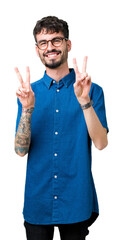 Sticker - Young handsome man wearing glasses over isolated background smiling looking to the camera showing fingers doing victory sign. Number two.