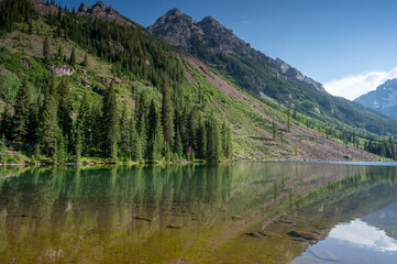 Wall Mural - Maroon Bells reflected in Maroon Lake on sunny summer afternoon under dramatic summer cloudscape.