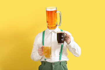 Canvas Print - Young man in traditional German clothes with beer on yellow background