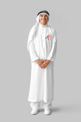 Sticker - Handsome Muslim man with red ribbon on grey background. AID awareness concept