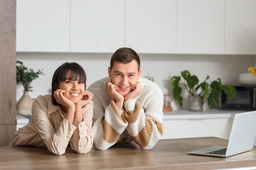 Wall Mural - Young loving couple at table in kitchen