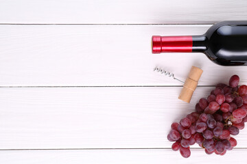 Poster - Corkscrew, bottle of wine and grapes on white wooden table, flat lay. Space for text