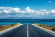 © Yurij - Tranquil asphalt road to ocean on summer beach, ideal for tourism trips, under blue sky, shore view