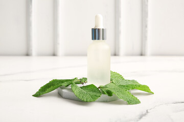 Wall Mural - Bottle of essential oil, plaster stand and mint leaves on light background, closeup