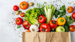 © Tanayut - Fresh vegetables spilling out of a paper bag on white background