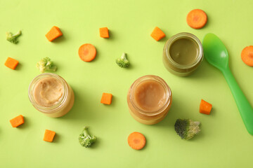 Poster - Composition with healthy baby food and pieces of vegetables on green background