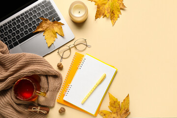 Wall Mural - Composition with modern laptop, notebooks, cup of tea and autumn leaves on color background