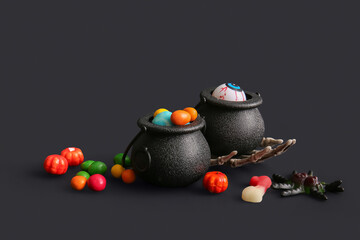 Wall Mural - Pots with different treats and decorations for Halloween on dark background