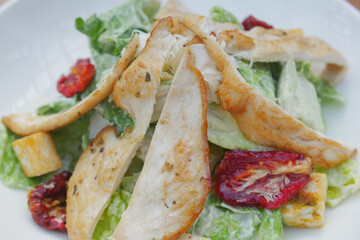 A fresh and appetizing Caesar Salad made with grilled chicken and sundried tomatoes