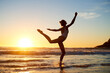 © peopleimages.com - Girl, dancer silhouette and sea for ballet at sunset, artist travel and practice movement by waves. Female person, freedom and dancing at dusk for performance, stretching and creative talent at beach