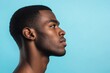 © Olena - Human Side-View. Serious African American Man Portrait in Profile Over Blue Studio Background