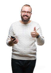 Wall Mural - Young caucasian hipster man texting sending message using smartphone over isolated background happy with big smile doing ok sign, thumb up with fingers, excellent sign