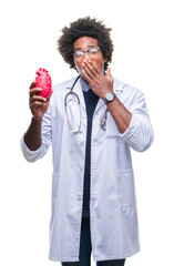 Sticker - Afro american cardiologist doctor man over isolated background cover mouth with hand shocked with shame for mistake, expression of fear, scared in silence, secret concept