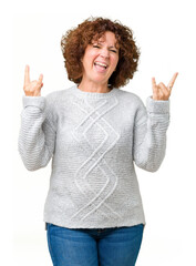 Sticker - Beautiful middle ager senior woman wearing winter sweater over isolated background shouting with crazy expression doing rock symbol with hands up. Music star. Heavy concept.