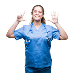 Sticker - Young brunette doctor girl wearing nurse or surgeon uniform over isolated background showing and pointing up with fingers number seven while smiling confident and happy.