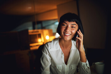 Aufkleber - Night, phone call and happy business woman in office for creative story, conversation or feedback. News, mobile and listen to contact for chat, talk or project deadline update with writer in startup