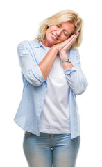 Canvas Print - Middle age blonde woman over isolated background sleeping tired dreaming and posing with hands together while smiling with closed eyes.