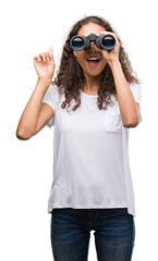 Poster - Young hispanic woman looking through binoculars surprised with an idea or question pointing finger with happy face, number one