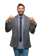 © Krakenimages.com - Adult hispanic business man over isolated background looking confident with smile on face, pointing oneself with fingers proud and happy.
