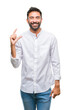 © Krakenimages.com - Adult hispanic man over isolated background smiling and confident gesturing with hand doing size sign with fingers while looking and the camera. Measure concept.