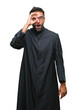 © Krakenimages.com - Adult hispanic catholic priest man over isolated background doing ok gesture shocked with surprised face, eye looking through fingers. Unbelieving expression.