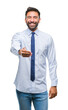 © Krakenimages.com - Adult hispanic business man over isolated background smiling friendly offering handshake as greeting and welcoming. Successful business.