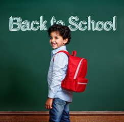 Boy with a backpack, standing in front of a school blackboard