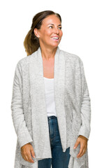 Poster - Beautiful middle age adult woman wearing winter sweater over isolated background looking away to side with smile on face, natural expression. Laughing confident.