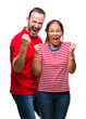 © Krakenimages.com - Middle age hispanic couple in love over isolated background celebrating surprised and amazed for success with arms raised and open eyes. Winner concept.
