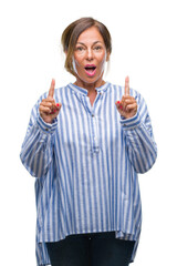 Canvas Print - Middle age senior hispanic woman over isolated background amazed and surprised looking up and pointing with fingers and raised arms.