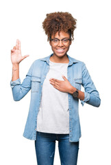 Wall Mural - Beautiful young african american woman wearing glasses over isolated background Swearing with hand on chest and fingers, making a loyalty promise oath