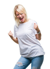 Wall Mural - Young beautiful blonde woman wearing white t-shirt over isolated background very happy and excited doing winner gesture with arms raised, smiling and screaming for success. Celebration concept.