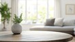 © berkah nikah - A potted plant on a round wooden table in a living room with a window and a sofa in the background