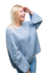 Canvas Print - Young beautiful blonde woman wearing winter sweater over isolated background very happy and smiling looking far away with hand over head. Searching concept.