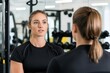 © JAYDA RIN - Female fitness coach guiding a client through exercises, goal-setting session, gym atmosphere