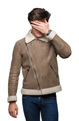 Sticker - Young handsome man wearing winter coat over isolated background smiling and laughing with hand on face covering eyes for surprise. Blind concept.