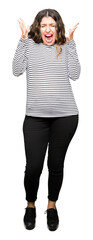 Canvas Print - Young beautiful woman wearing stripes sweater celebrating crazy and amazed for success with arms raised and open eyes screaming excited. Winner concept