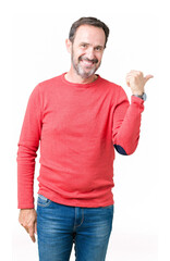 Wall Mural - Handsome middle age hoary senior man wearing winter sweater over isolated background smiling with happy face looking and pointing to the side with thumb up.